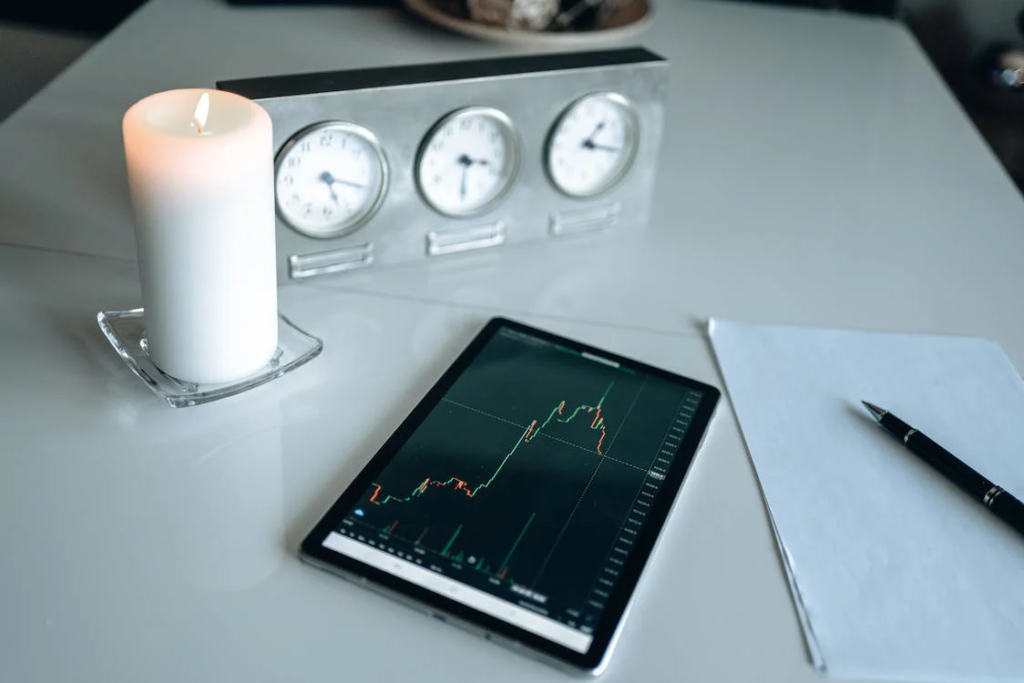 черный ipad, на котором показан рост акций,2 на белом столе